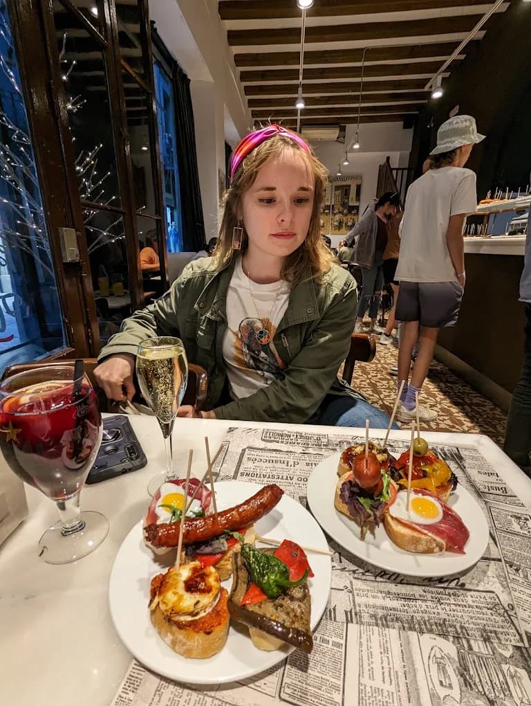 Clienta disfrutando de una mesa de tapas y cava