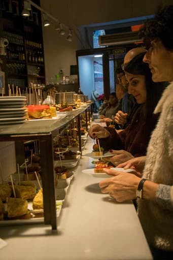 Clientes eligiendo tapas en el mostrador de El Drac de Sant Jordi